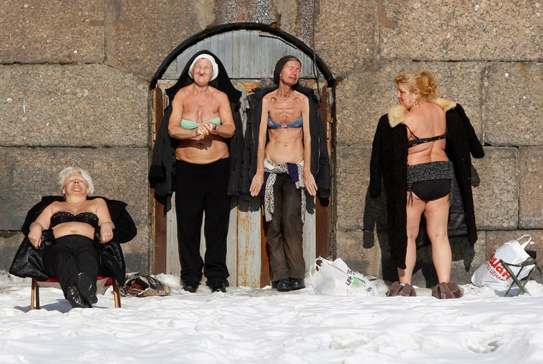 People sunbathe by the wall of the Peter and Paul Fortress in St. Petersburg March 10, 2013. REUTERS/Alexander Demianchuk (RUSSIA - Tags: SOCIETY RELIGION TPX IMAGES OF THE DAY) - RTR3ET00