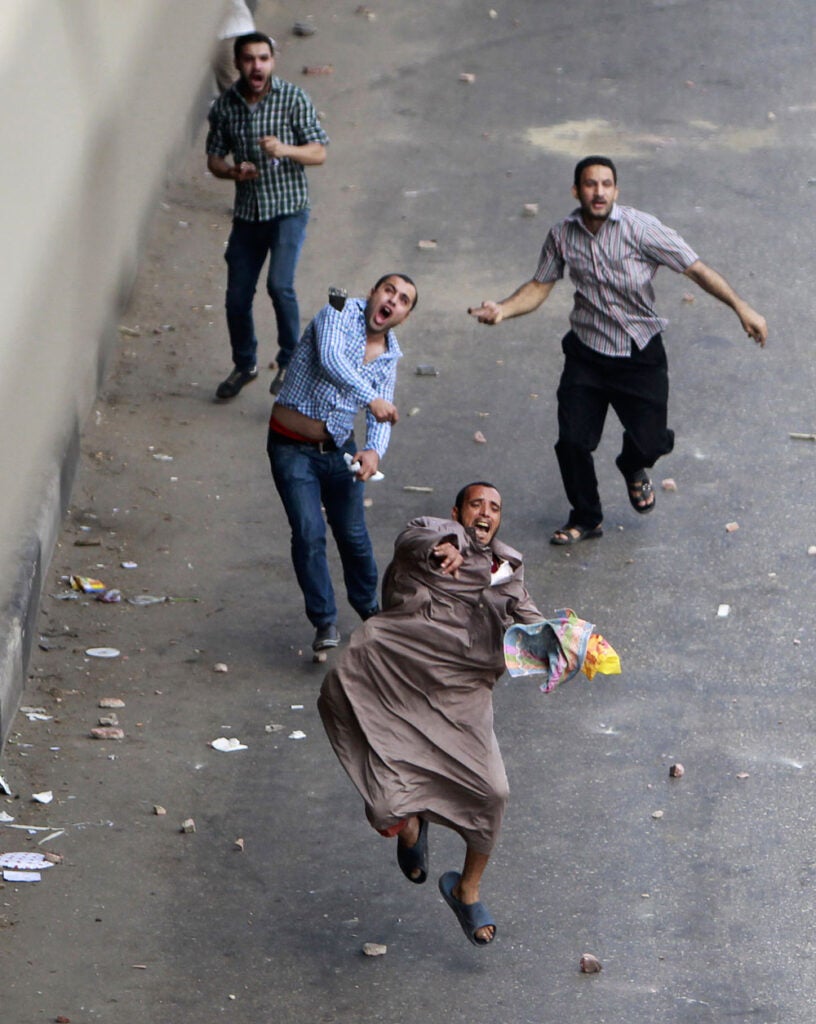 Members of the Muslim Brotherhood and supporters of ousted Egyptian President Mohamed Mursi throw stones at riot police during clashes around Cairo University and Nahdet Misr Square, where they are camping in Giza, south of Cairo. Security forces killed hundreds during the clashes. Mohamed Abd El Ghany, who also shot the previous photo, is a Reuters staffer based in Cairo. He also shoots for the <em><a href="http://www.egyptindependent.com/">Egypt Independent</a>.</em>