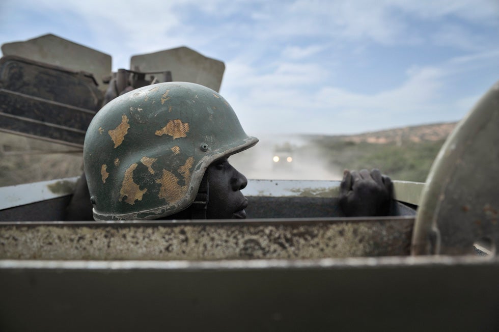 A soldier peers out of the top of an armored vehicle on a road just outside the city of Merca, Somalia. Tobin Jones is a freelance photographer based in Eastern Africa. A 2009 graduate of McGill Univeristy, Tobin works in and around Kenya. See more of his work <a href="http://www.tobinjonesphotography.com/">here</a>.