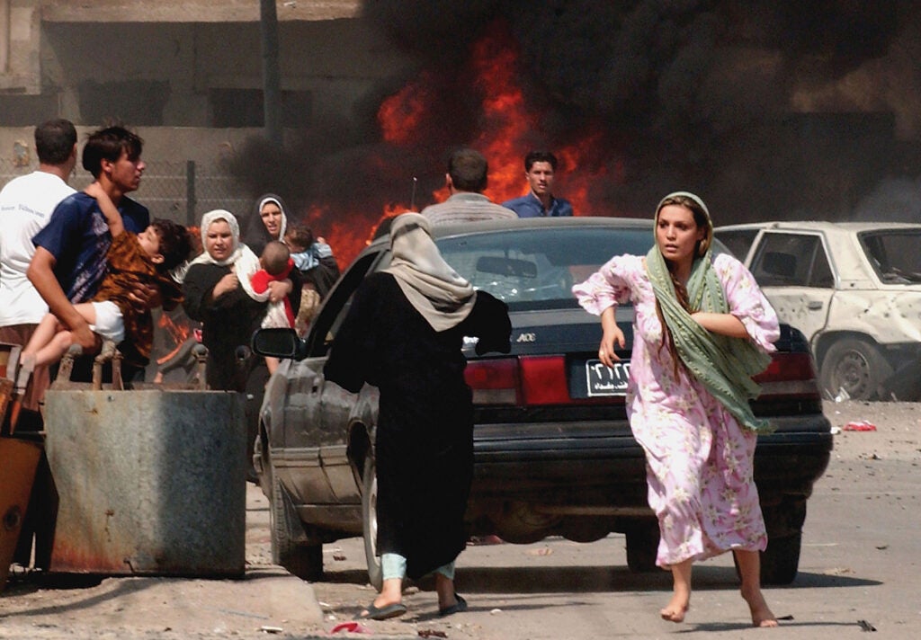 Iraqi citizens flee the scene after three explosions September 30, 2004 in Baghdad, Iraq. From: <em>War is Beautiful</em> by David Shields, published by powerHouse Books.