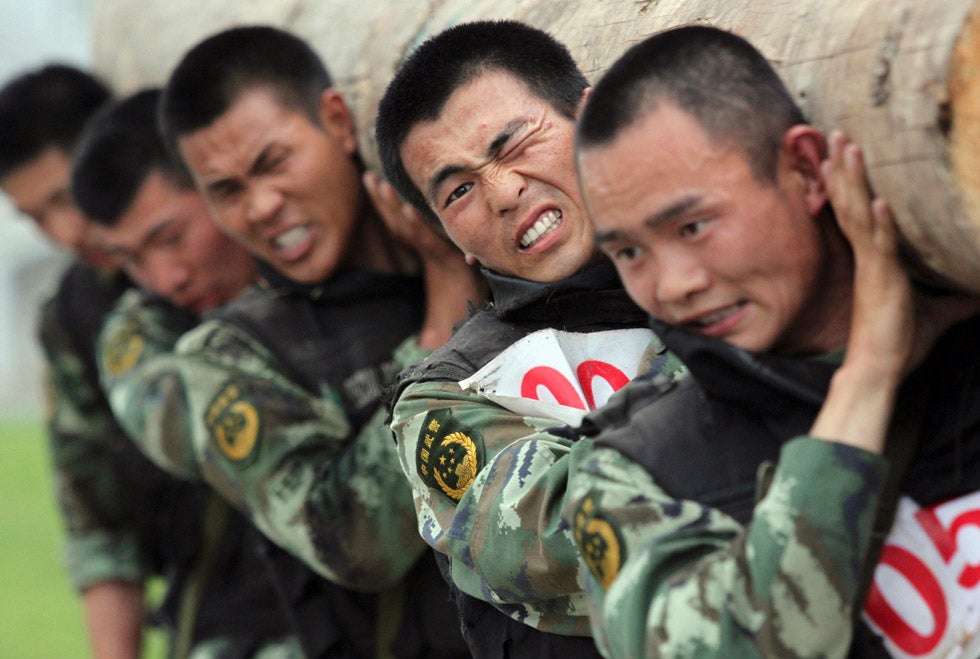 Chinese paramilitary police train at a base in Nanjing, China, by carrying a log on their shoulders.