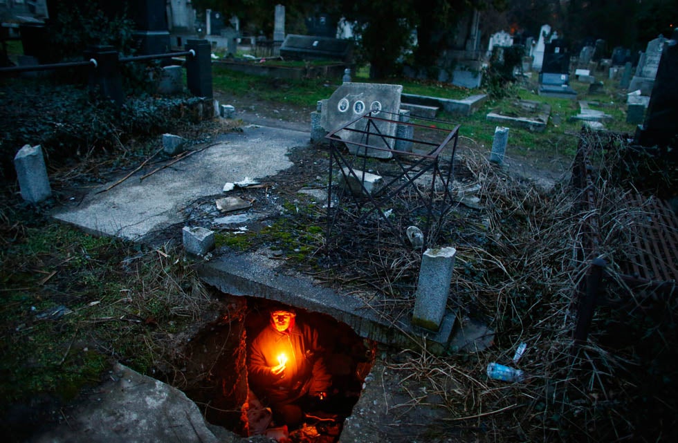 Bratislav Stojanovic, a homeless man, holds candles as he sits in a tomb where he lives in southern Serbian town of Nis. Stojanovic, 43, a Nis-born construction worker never had a regular job. He first lived in abandoned houses, but about 15 years ago he settled in the old city cemetery. Marko Djurica is a Reuters staffer covering general and breaking news in Serbia. See more of his work <a href="http://www.americanphotomag.com/photo-gallery/2012/09/photojournalism-week-september-14-2012-0?page=10">here</a>.