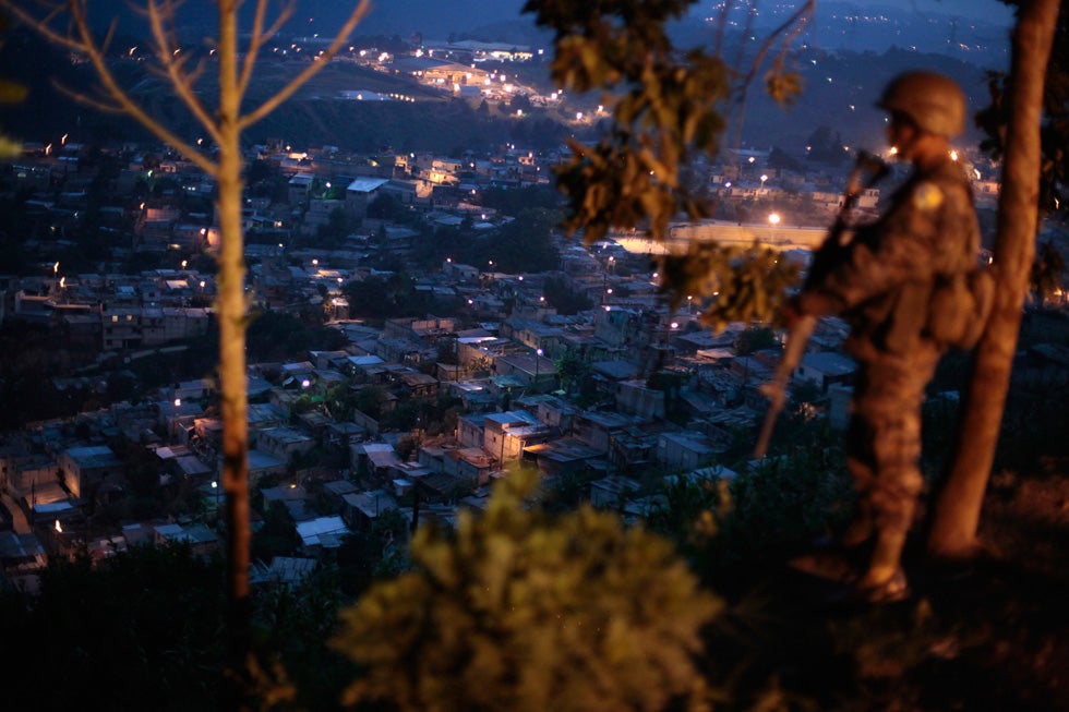 A soldier of the Fuerza de Tarea Maya (Maya Task Force) stands watch during a patrol overlooking Zona 18, in the northern part of Guatemala City, Guatemala. Jorge Lopez is a photojournalist based in Guatemala and shooting for Reuters.