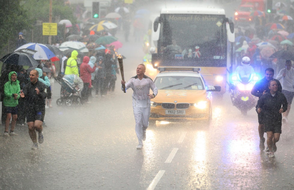 Glenn Chambers carries the Olympic Flame near Lincoln, England, during a heavy downpour, on Day 41 of the London 2012 Olympic Torch Relay. Chris Radburn is an Associated Press photographer also shooting for the London Organising Committee of the Olympic and Paralympic Games.