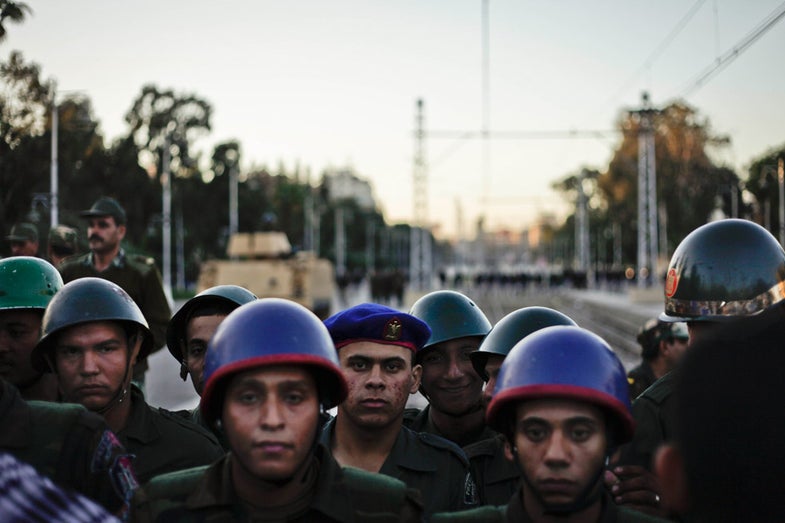 Egyptian army soldiers stand guard during a demonstration in front of the presidential palace in Cairo, Egypt, Friday, Dec. 7, 2012. Egypt's political crisis spiraled deeper into bitterness and recrimination on Friday as large crowds of the Egyptian President Mohammed Morsi's opponents marched to his palace to increase pressure after he rejected their demands. (AP Photo/Nariman El-Mofty)
