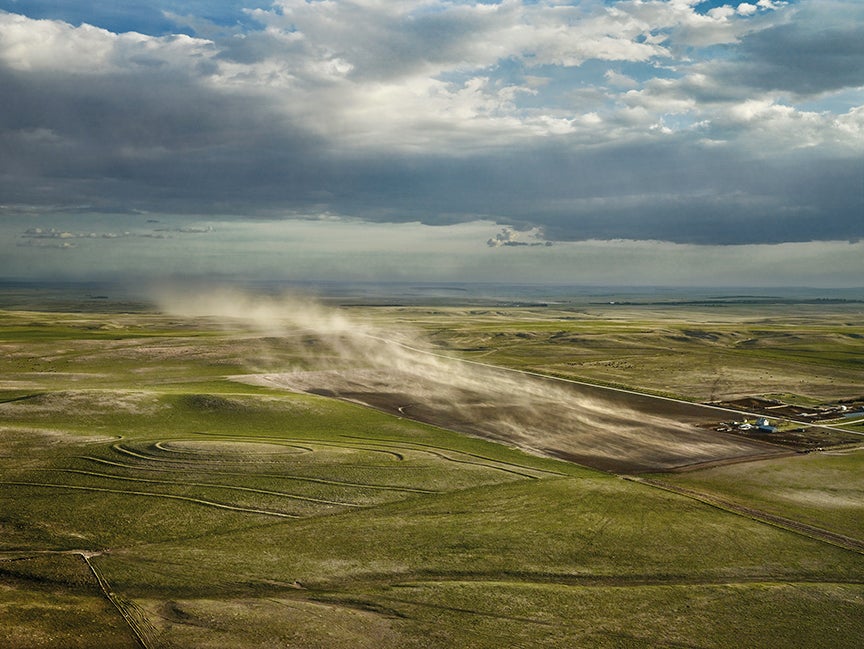 These dry, fallow lands and terraces lie to the southeast of Clinton.  The wind coming out of the north was blowing at over seventy m.p.h.  When choosing the angle of approach to a subject, Doug Dean piloted us if possible into a headwind, since that slowed the plane down and allowed a bit more time for picture-making.  On this day we had little choice but to let a powerful tailwind take us on a Nantucket sleighride if we wanted to catch this billowing cloud of white dirt.