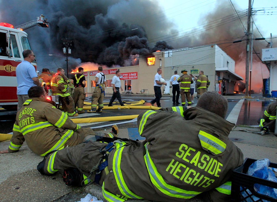 Almost five hours into the battle, weary Seaside Heights firefighters take a break after fighting a fast moving fire as it consumes the south end of the Seaside Boardwalk. 9/12/2013