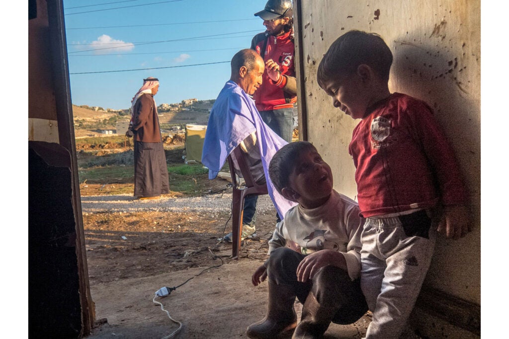 "In the camp where I live, this is what the operation of getting your hair cut looks like. A barber is called and the operation is often done outside in order to keep the tents clean."