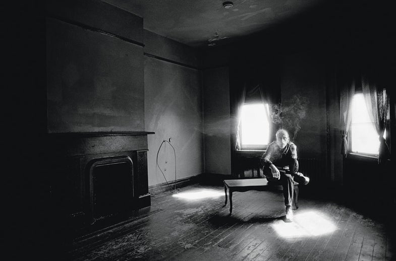 Man Smoking Cigarette in Bare Living Room