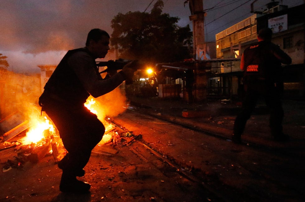 A policeman takes up position at the Jacarezinho slum during an operation to install Peacekeeping Unit (UPP) riot police in Rio de Janeiro, Brazil. The introduction of the peacekeeping program in the region is part of efforts to crack down on crime and increase security as the city prepares to host the 2014 soccer World Cup and the 2016 Olympic Games. Sergio Moraes is a Brazilian-based photojournalist shooting for Reuters.