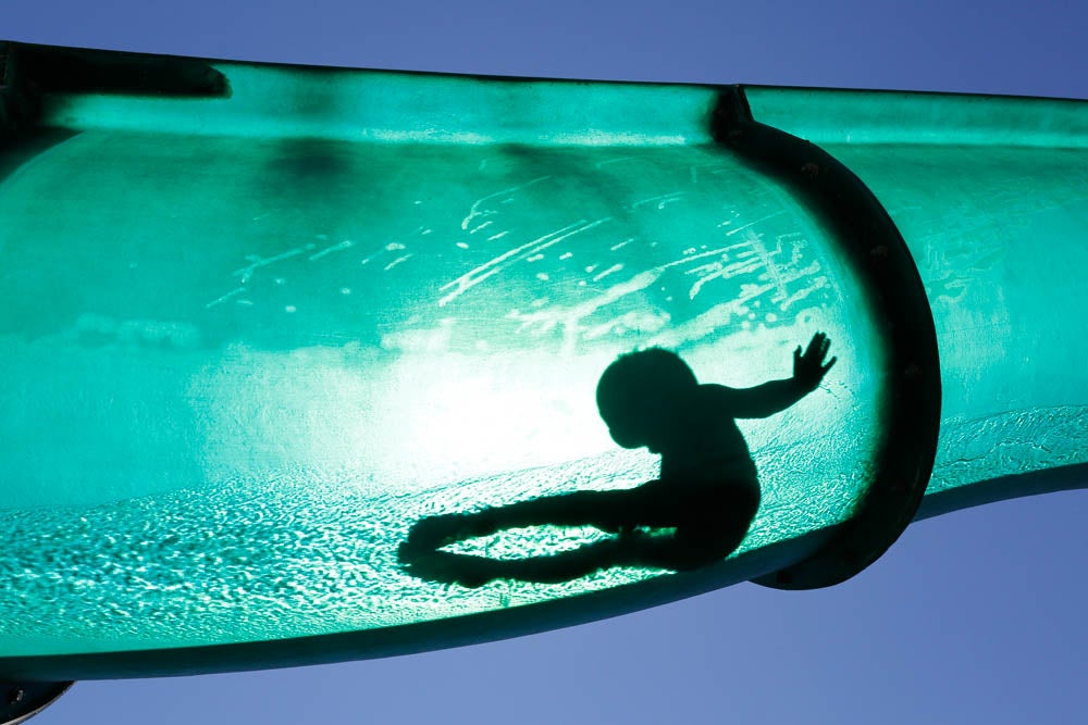 A boy slides down a water chute in a public swimming pool in Thun August 1, 2013. REUTERS/Ruben Sprich  (SWITZERLAND - Tags: ENVIRONMENT SOCIETY TPX IMAGES OF THE DAY) - RTX1274L