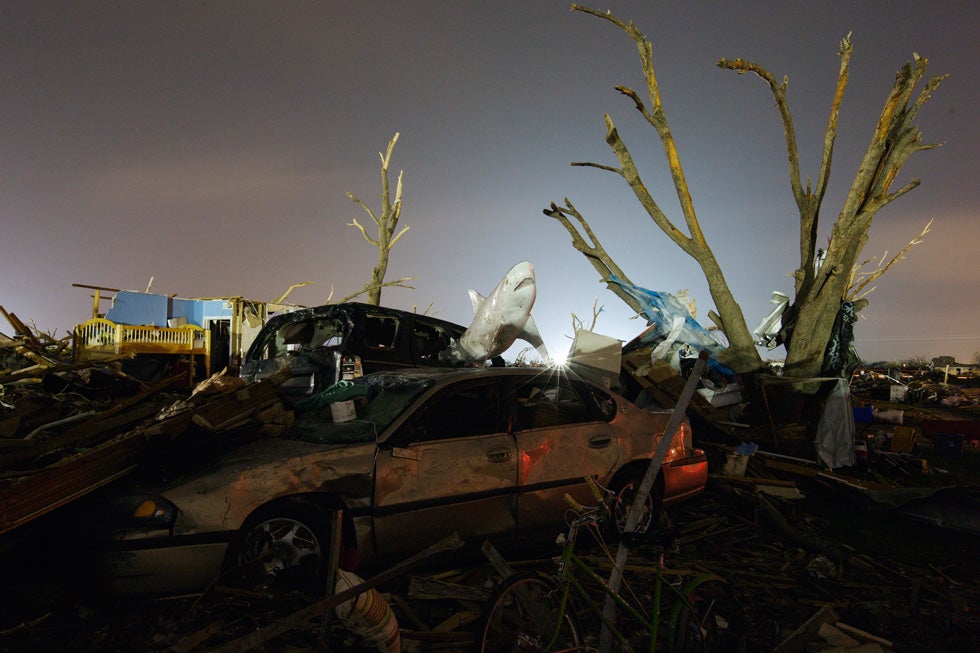 The evening light illuminates a toy shark on top of a car and a tree stripped by the wind in an area heavily damaged by the May 20 afternoon tornado in Moore, Oklahoma May 27, 2013. The tornado was the strongest in the United States in nearly two years and cut a path of destruction 17 miles (27 km) long and 1.3 (2 km) miles wide. REUTERS/Lucas Jackson (UNITED STATES - Tags: DISASTER ENVIRONMENT TRANSPORT) - RTX102MI