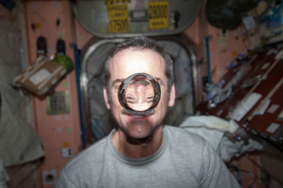Canadian Space Agency astronaut Chris Hadfield, Expedition 34 flight engineer, watches a water bubble float freely between him and the camera. Hadfield is the first Canadian commander of the International Space Station.