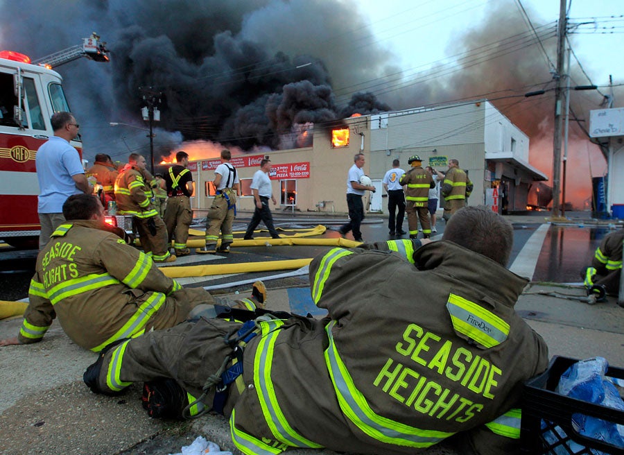 Almost five hours into the battle, weary Seaside Heights firefighters take a break after fighting a fast moving fire as it consumes the south end of the Seaside Boardwalk. 9/12/2013 (Andrew Mills/The Star-Ledger)