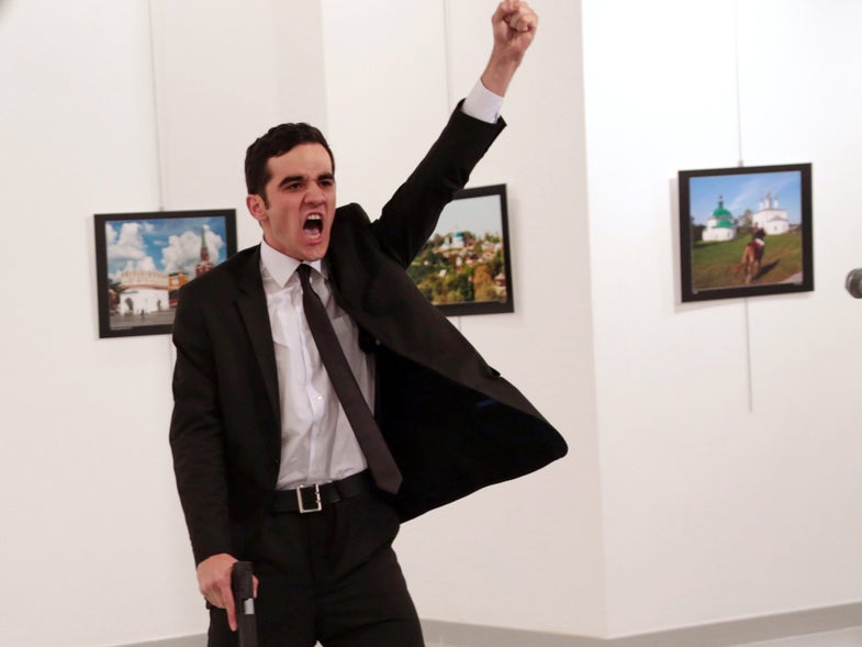 Mevlut Mert Altintas shouts after shooting Andrei Karlov, right, the Russian ambassador to Turkey, at an art gallery in Ankara, Turkey, Monday, Dec. 19, 2016. (AP Photo/Burhan Ozbilici)