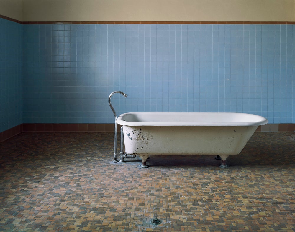 "There’s only a single tub in the entire room. It has no controls. They were located on a nearby wall so that patients couldn’t adjust temperature or water flow. There’s a beautiful simplicity to the scene, and the tub has a sculptural feel. The room is well-constructed —the tile is in perfect condition after decades of use. The space is clean and clinically functional, with a very carefully designed layout. This approach and this look of logical design is very common in the mental institutions of the period. The illumination is ambient light that pours through large windows and doors, both beautiful and practical."