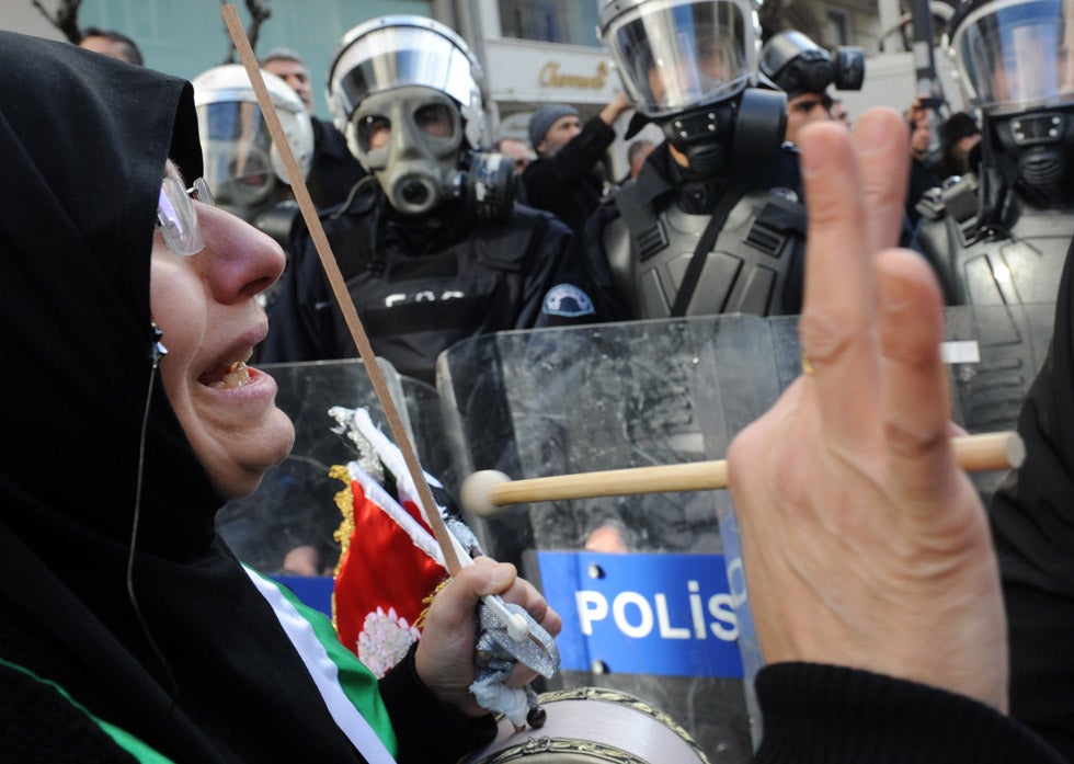 A female protestor clashes with police officers outside the Syrian consulate in Istanbul, Turkey. Demonstrators in many European countries, including Turkey and Great Britain, have taken to the streets to voice their disapproval of Syrian President Bashar al-Assad, who is violently squashing opposition protesters in his own country. Getty Images stringer <a href="http://www.lightstalkers.org/bulent_kilic">Bulent Kilic</a>, who made this image, was born and raised in Turkey. He graduated the Aegean Journalism Facility in 2003, and has been working as a stringer for AFP and various other Turkish publications for the past nine years. He currently lives and work in Istanbul.