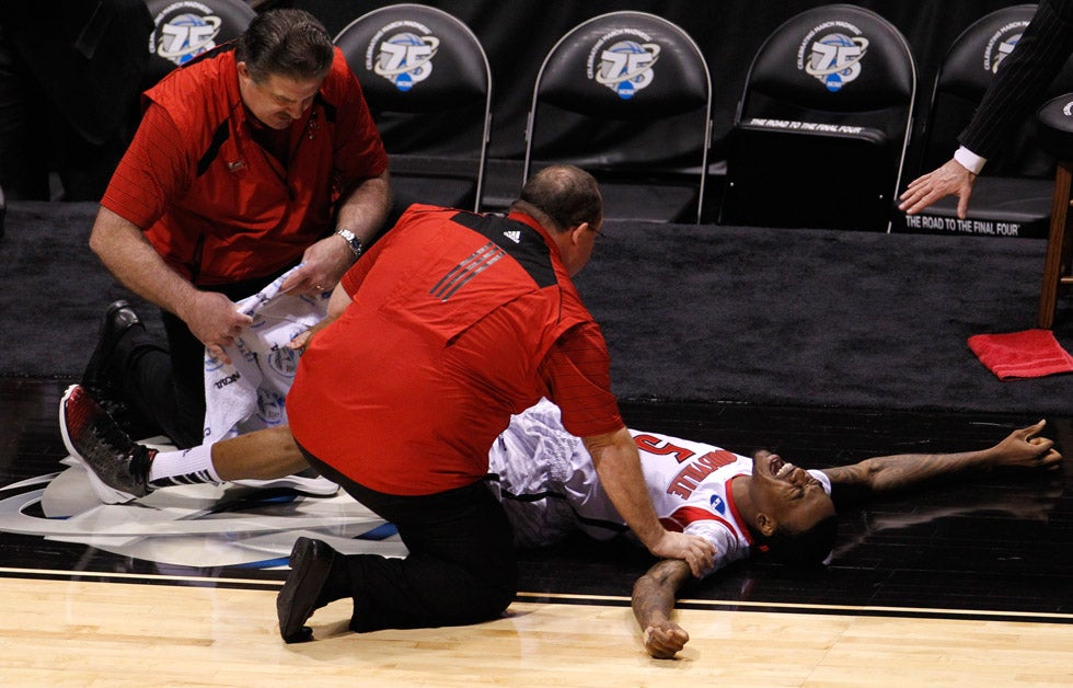 Louisville Cardinals guard Kevin Ware (5) is attended to by medical staff after breaking his leg in the first half against the Duke Blue Devils during their Midwest Regional NCAA men's basketball game in Indianapolis, Indiana. John Sommers II is a Louisville-based independent photographer. See more of his work <a href="http://www.sommersphoto.com/index.htm">here</a>.