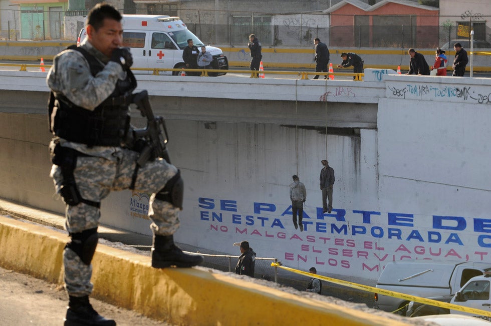 A police officer stands guard at a crime scene where two men were found hanging from a bridge in Atizapan de Zaragoza near Mexico City. Alejandro Dias is a stringer working for Reuters in Mexico City, Mexico.