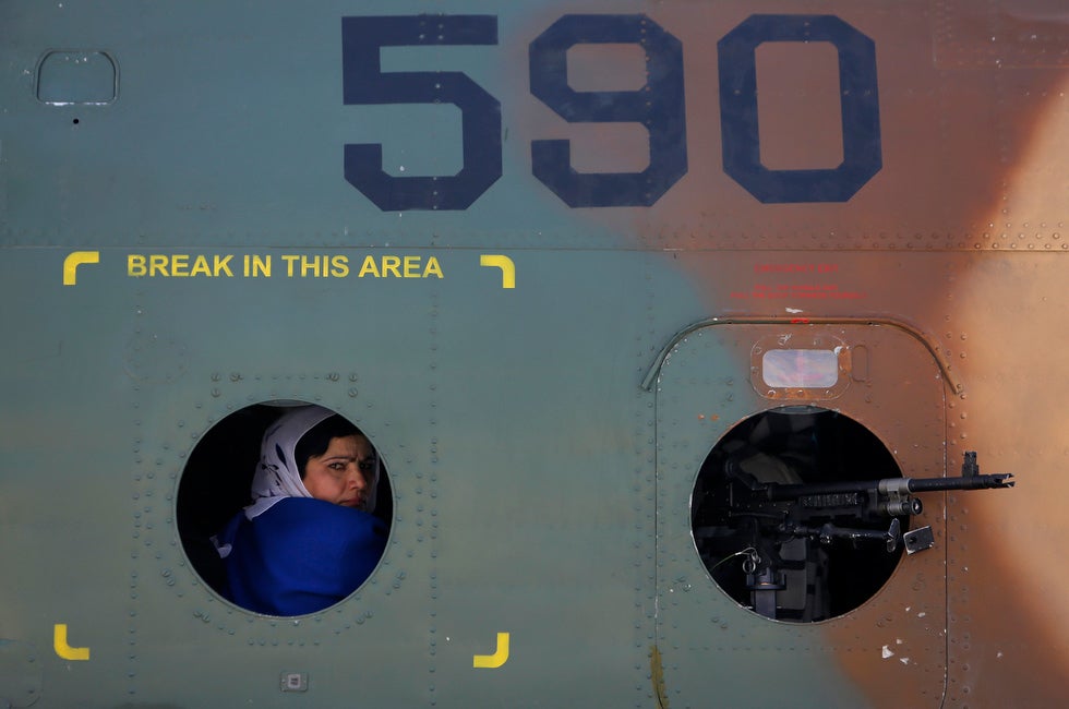 An Afghan woman looks out from a helicopter window at International Airport in Kabul, Afghanistan. Mohammad Ismail is a photojournalist working for Reuters in Afghanistan.