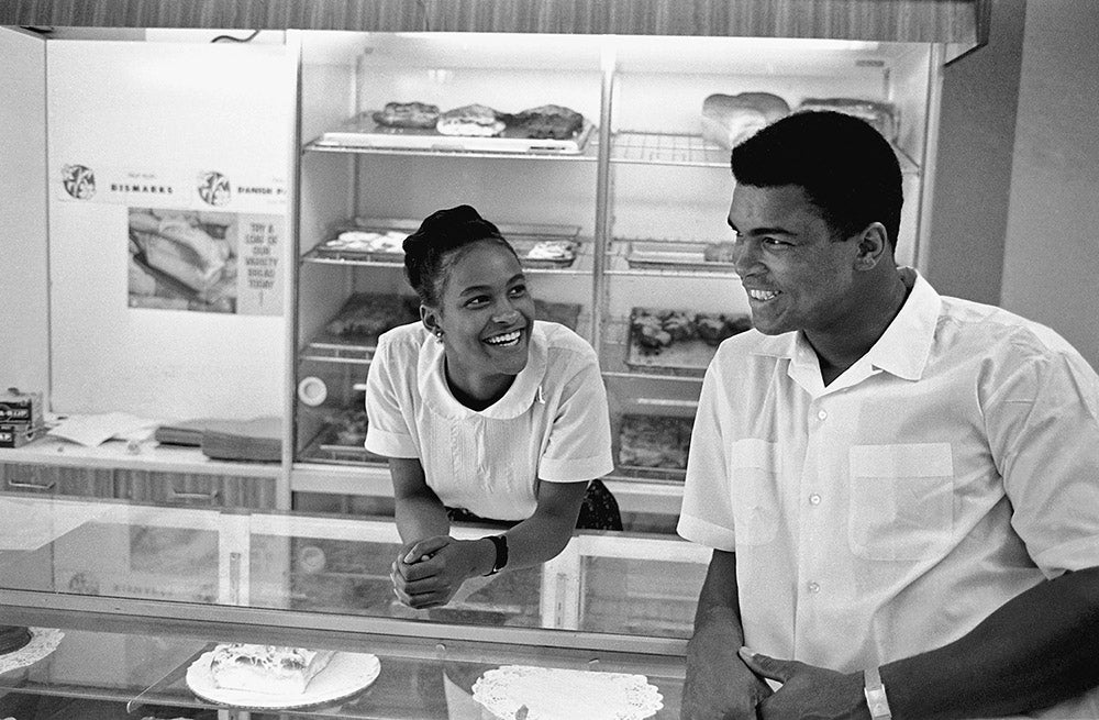 Muhammad Ali flirts with Belinda Boyd in a bakery shop. Belinda later became Ali's second wife as Khalilah Ali. Chicago, Illinois, 1966.