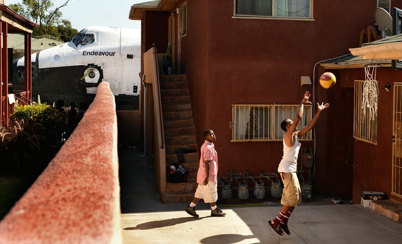 Traymond Harris (L) and Ryan Hudge play basketball as Space Shuttle Endeavour travels to the California Science Center on Crenshaw Ave in Inglewood, Los Angeles October 13, 2012. REUTERS/Wally Skalij/Pool (UNITED STATES - Tags: SCIENCE TECHNOLOGY TRANSPORT)