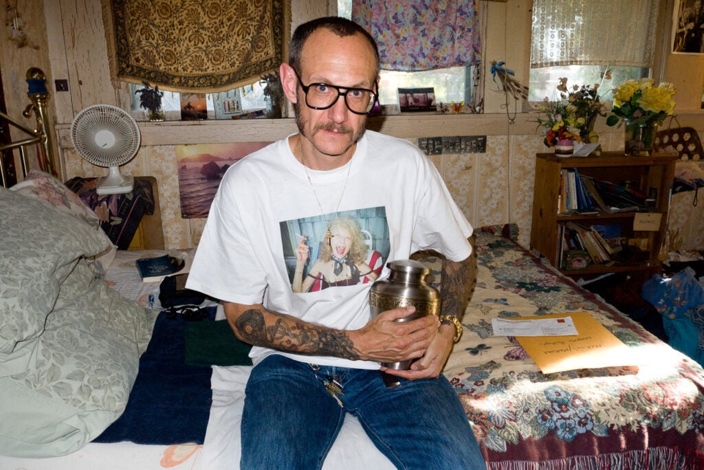 "Me holding my Momâs urn on her bed."