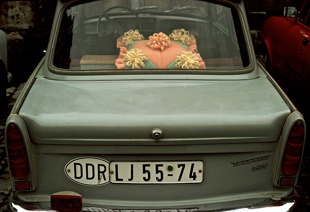 The rear window of a "Trabbi" (Trabant) car with a decorative plastic cushion. East Germany, 1974.