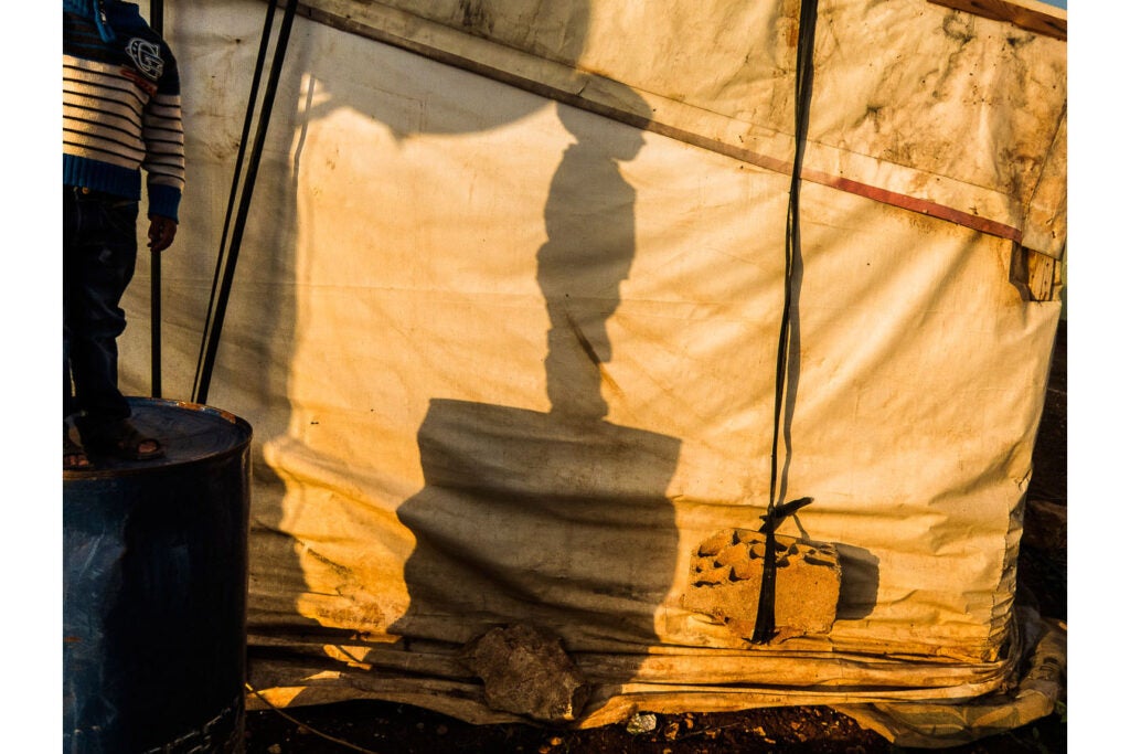 "My little brother Ashraf standing on a barrel in the camp. He dances like angels. He spreads joy everywhere and this might not be Ashraf. Maybe Ashraf is just one who is supposed to be a child with all his simple rights intact."