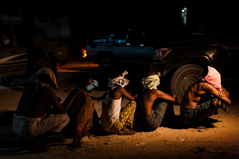 Men believed to be members of al Shabaab sit in the street after being arrested by Somali National Intelligence during a cordon and search operation in Mogadishu, Somalia, May 4, 2014.