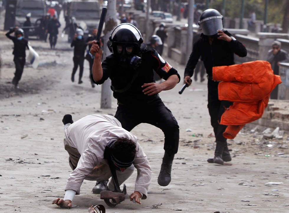 Riot policemen beat a protester opposing Egyptian President Mohamed Mursi, during clashes along Qasr Al Nil bridge, which leads to Tahrir Square in Cairo. Amr Dalsh is a Reuters staffer based in Cairo, Egypt, who has been with the organization since 2006. See more of his work <a href="http://www.americanphotomag.com/photo-gallery/2012/12/photojournalism-week-december-14?page=5">here</a>.