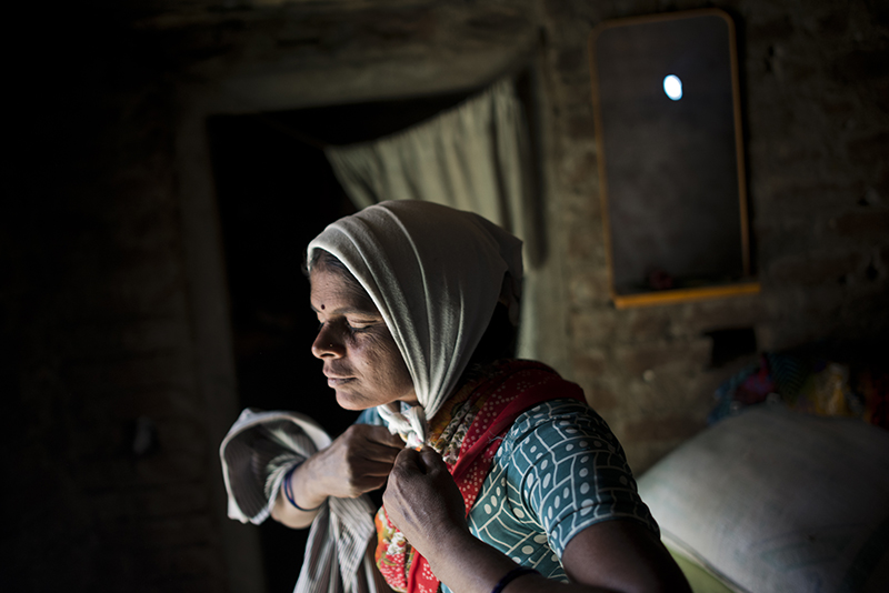 Kala Lakavath a "cotton widow" in Andhra Pradesh, India, prepares for a long day in the fields to pay off her family's debts. Her husband committed suicide by drinking pesticide three years ago. Andhra Pradesh, India. November 15, 2013. <em>Andrea Bruce is a documentary photographer who brings attention to people living in the aftermath of war. In 2012 she was the first photojournalist to be awarded the Chris Hondros Fund Award. See more of her work <a href="http://www.andreabruce.com/">here. </a></em>