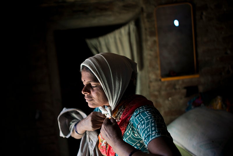 Kala Lakavath a "cotton widow" in Andhra Pradesh, India, prepares for a long day in the fields to pay off her family's debts. Her husband committed suicide by drinking pesticide three years ago. Andhra Pradesh, India. November 15, 2013. <em>Andrea Bruce is a documentary photographer who brings attention to people living in the aftermath of war. In 2012 she was the first photojournalist to be awarded the Chris Hondros Fund Award. See more of her work <a href="http://www.andreabruce.com/">here. </a></em>