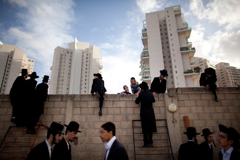 BNEI BRAK, ISRAEL - MARCH 14: (ISRAEL OUT) Thousands of ultra-Orthodox Jews of the Vizhnitz Hasidic dynasty stand on ladders as they follow the funeral procession of their rabbi Moshe Yhoshua Hager's body wrapped in a prayer Shawl before his funeral on March 14, 2012 in Bnei Brak, Israel. Rabbi Moshe Yehoshua Hager, who was the head of Israel's second largest Hasidic community, died aged 95 and was buried beside his father's grave in the Tel Aviv suburb of Brei . (Photo by Uriel Sinai/Getty Images)