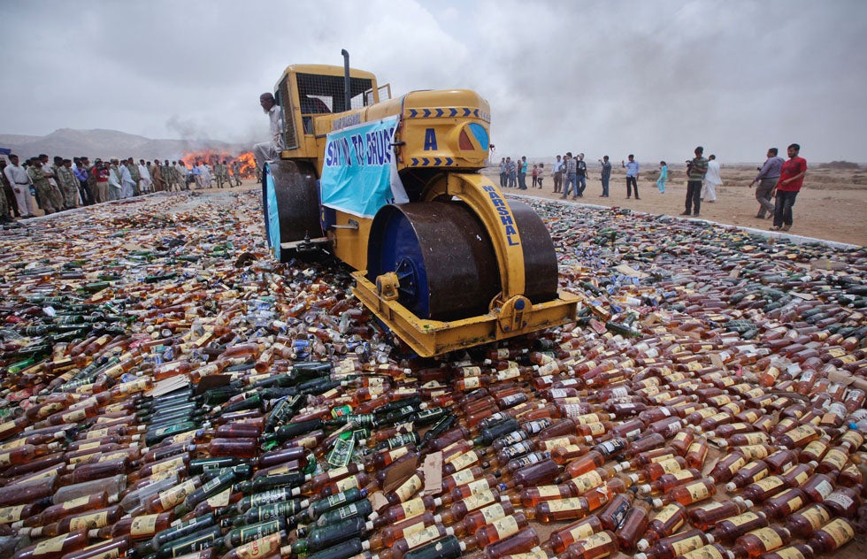Coast guard officers and members of the media watch as a steamroller moves through a pile of confiscated liquor bottles near Karachi, Pakistan, during a campaign to mark the International Day against Drug Abuse and Illicit Trafficking. Akhtar Soomro is a Reuters staffer based in Karachi. In 2009, he was part of a <em>New York Times</em>' team that won a Pulitzer Prize for their coverage of Iraq and Afghanistan. See a portfolio of his work on the <a href="http://blogs.reuters.com/fullfocus/2010/11/08/portfolio-akhtar-soomro/">Reuters blog</a>.