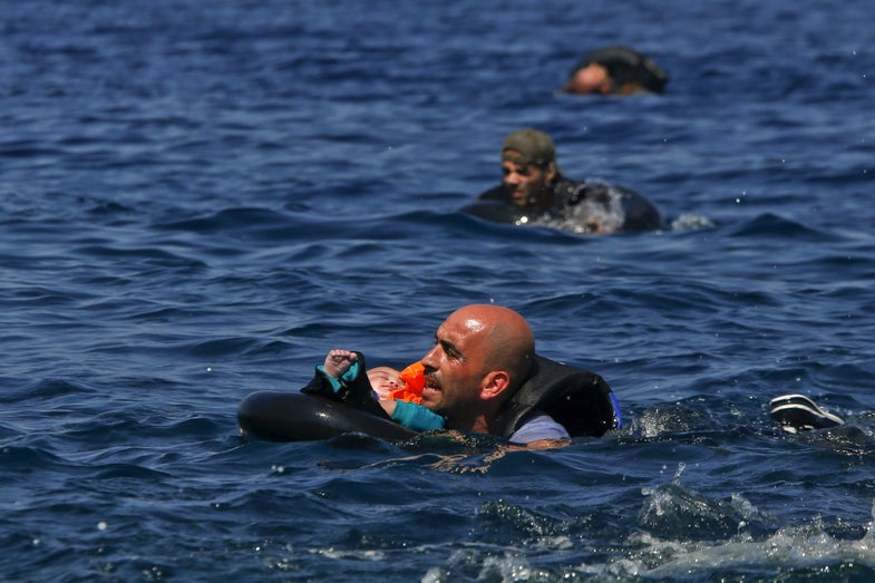 A Syrian refugee holding a baby in a life tube swims towards the shore after their dinghy deflated some 100m away before reaching the Greek island of Lesbos, September 13, 2015. Reuters and The New York Times shared the Pulitzer Prize for breaking news photography for images of the migrant crisis in Europe and the Middle East. REUTERS/Alkis Konstantinidis TPX IMAGES OF THE DAY - RTX2AJKA