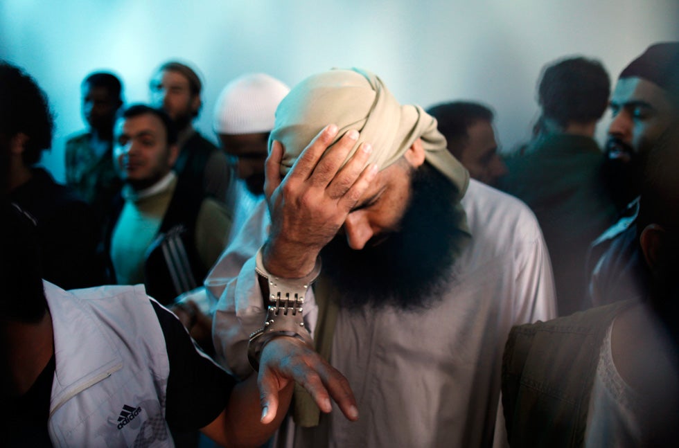 A suspected al Qaeda militant holds his head as he stands with co-defendants behind bars at the state security court of appeals in Sanaa, Yemen. The court on Tuesday upheld jail sentences ranging from four to 10 years against 10 defendants convicted of having links to al Qaeda. Khaled Abdullah is a Reuters staff photographer based in Yemen. Check out more of his work <a href="http://www.americanphotomag.com/photo-gallery/2012/03/photojournalism-week-march-30-2012?page=10">here</a>.