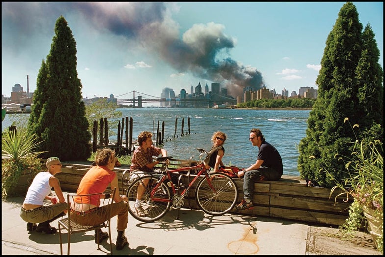 USA. Brooklyn, New York. September 11, 2001. Young people relax during their lunch break along the East River while a huge plume of smoke rises from Lower Manhattan after the attack on the World Trade Center. Contact email: New York : photography@magnumphotos.com Paris : magnum@magnumphotos.fr London : magnum@magnumphotos.co.uk Tokyo : tokyo@magnumphotos.co.jp Contact phones: New York : +1 212 929 6000 Paris: + 33 1 53 42 50 00 London: + 44 20 7490 1771 Tokyo: + 81 3 3219 0771 Image URL: http://www.magnumphotos.com/Archive/C.aspx?VP3=ViewBox_VPage&IID=2K7O3RK0762&CT=Image&IT=ZoomImage01_VForm