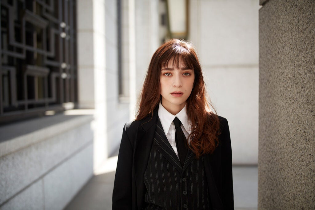 girl in black tie with red-brown hair