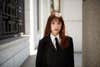 girl in black tie with red-brown hair