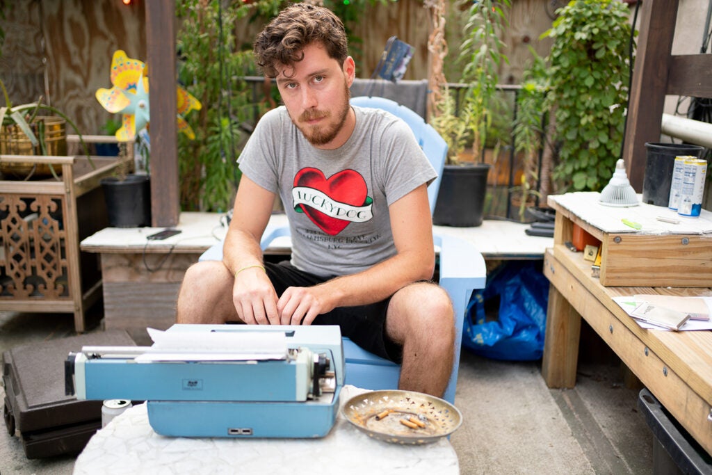 man sitting with blue typewriter