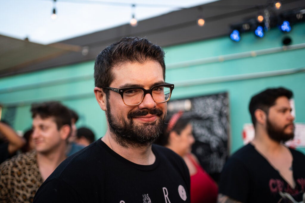 man smiling in front of aqua building