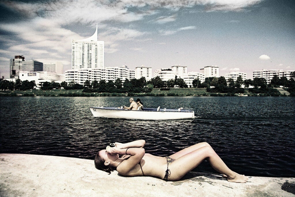 girl laying on the beach and photographing the sky