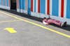 man in pink suit lying in the shade on the street