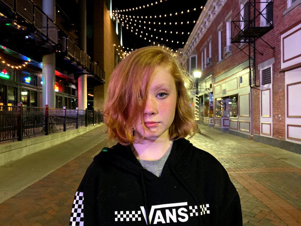 A back-lit girl on a dark street