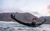 surfer Mick Fanning swimming in wetsuit