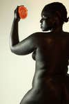 dark skinned woman holding fruit in front of her