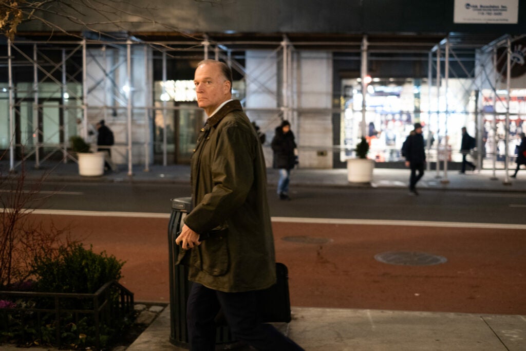 man walking with luggage in coat