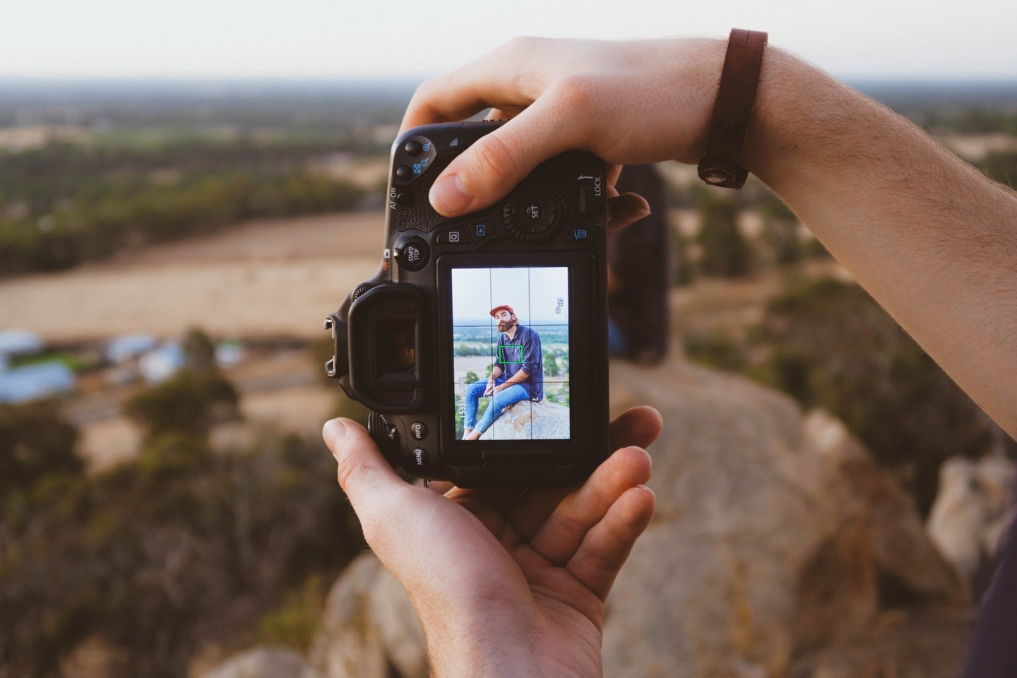 Person taking portrait with DSLR camera