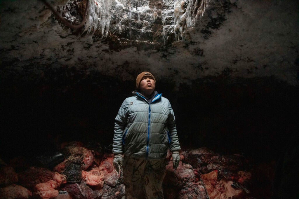 After a successful hunt, Josiah Olemaun, a young whaling crew member takes a break from moving and stacking whale meat into his familyâs ice cellar in Utqiagvik, Alaska.